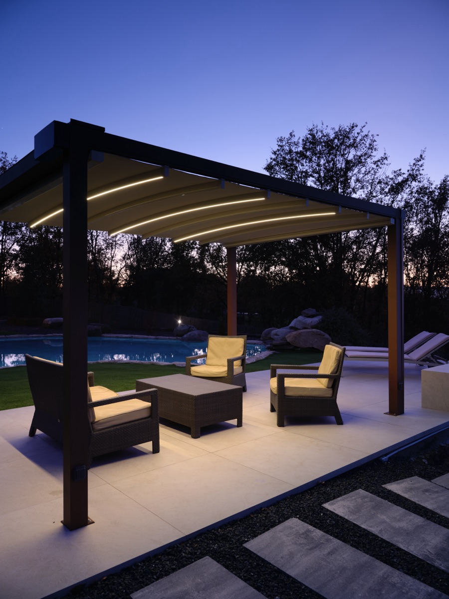 Moderne Pergola mit integrierter LED-Beleuchtung als stilvolle Überdachung eines Sitzbereichs am Pool – elegante Lösung im Bereich moderner Überdachungen, die Design und Funktion vereint.