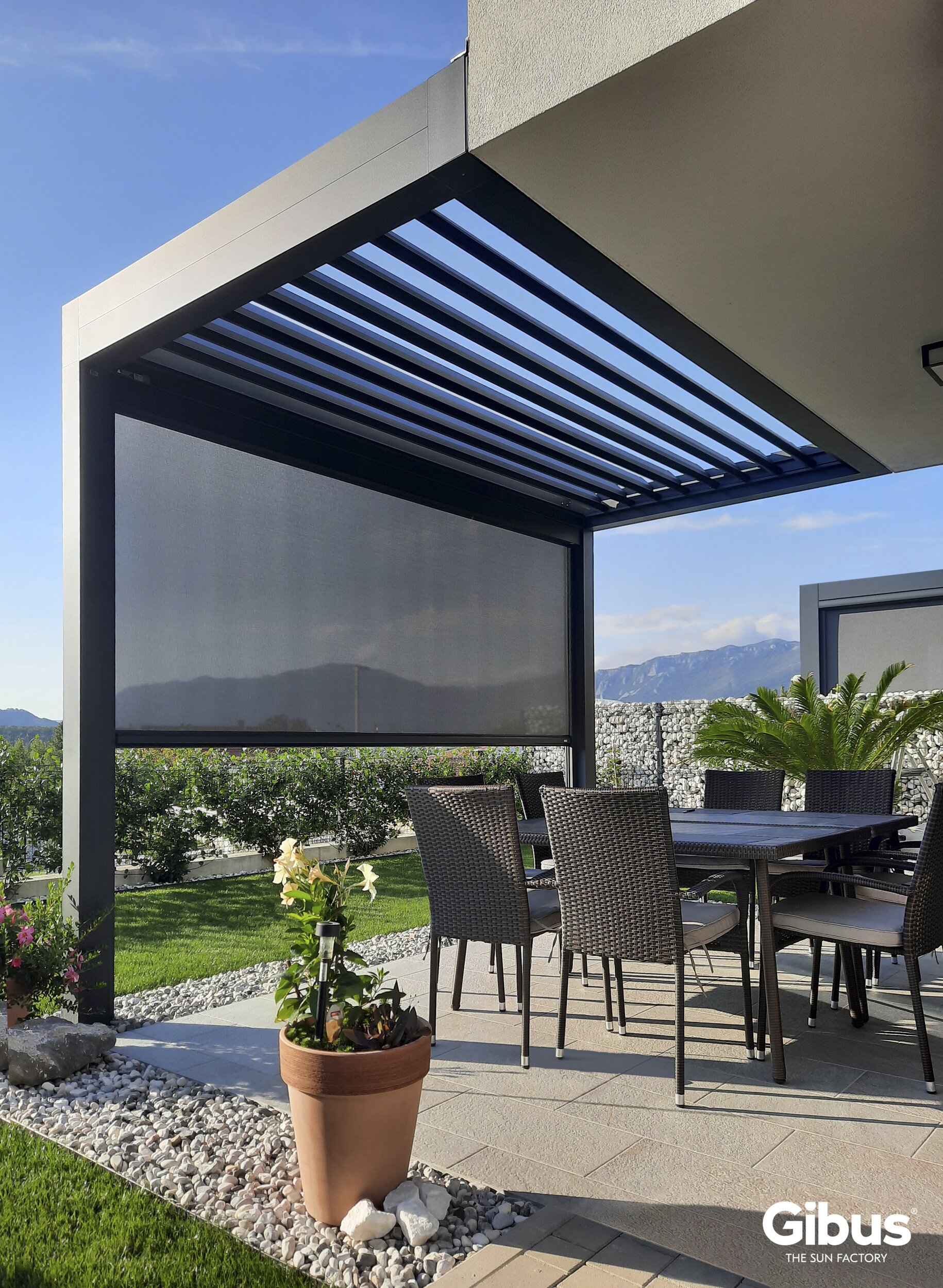 Terrasse mit modernem Lamellendach und seitlichem Sonnenschutz-Screens – stilvolle Lösung für wettergeschützten Outdoor-Komfort.